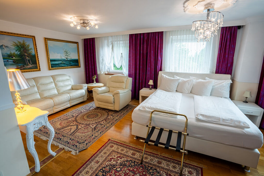 Elegant eingerichtetes Hotelzimmer im Höckner Plaza mit Kronleuchter und stilvollen Möbeln – Ansicht 1