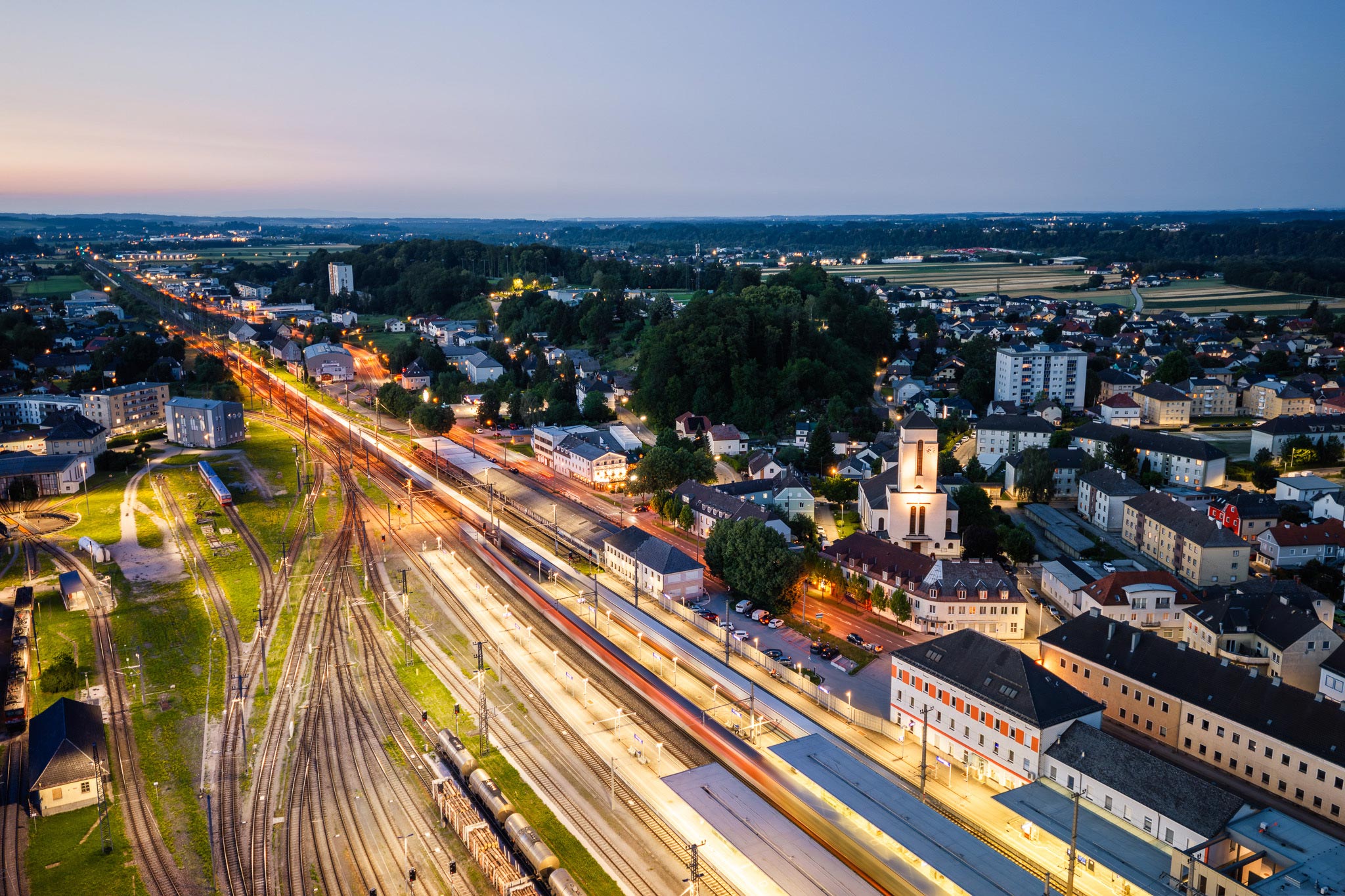 Luftaufnahme von Attnang-Puchheim bei Nacht mit Bahnhof und Hauptverkehrsachse B1